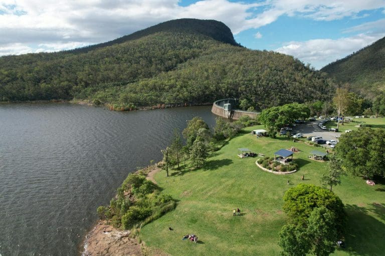 Aerial View of a Park beside and Body of Water and Mountains 